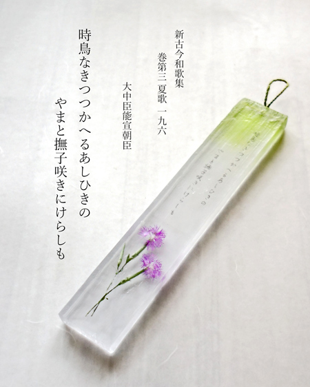レジンに和歌を印刷した和紙を固めたレジン製の短冊の画像