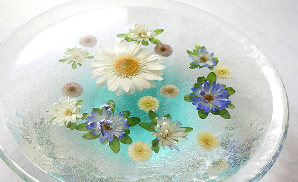 ガラスの器にガーベラやアスター,小菊などの花のアメージングドライフラワーをレジンに浮かべて固めた花手水風のインテリア